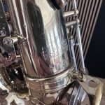 Close-up of a chrome motorcycle engine case with bolts and etched serial numbers visible on the metal surface.